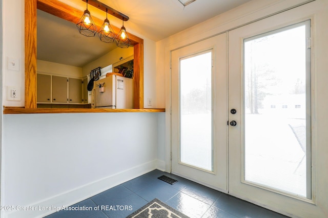 doorway featuring dark tile patterned flooring, french doors, and a healthy amount of sunlight