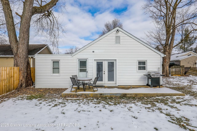 snow covered rear of property featuring french doors