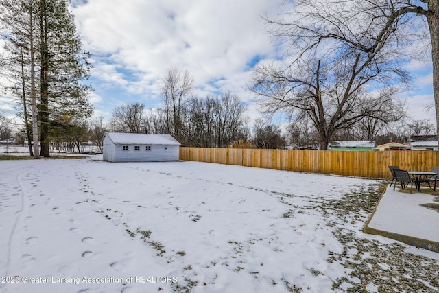 yard layered in snow with a storage shed