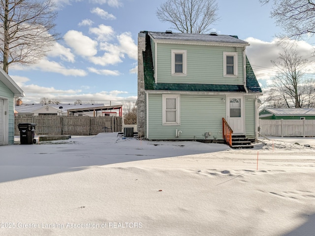 snow covered house featuring central air condition unit