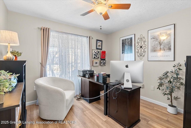 office area featuring ceiling fan, light hardwood / wood-style flooring, and a textured ceiling