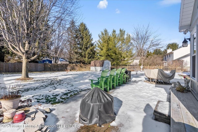 snow covered patio featuring a storage shed