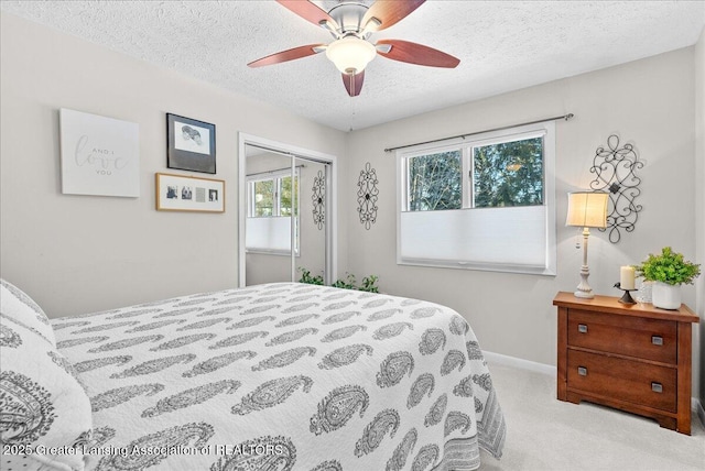 carpeted bedroom featuring ceiling fan, a closet, and a textured ceiling