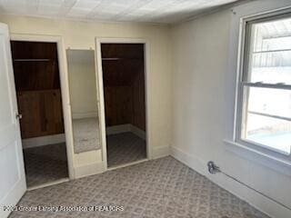 unfurnished bedroom featuring multiple windows