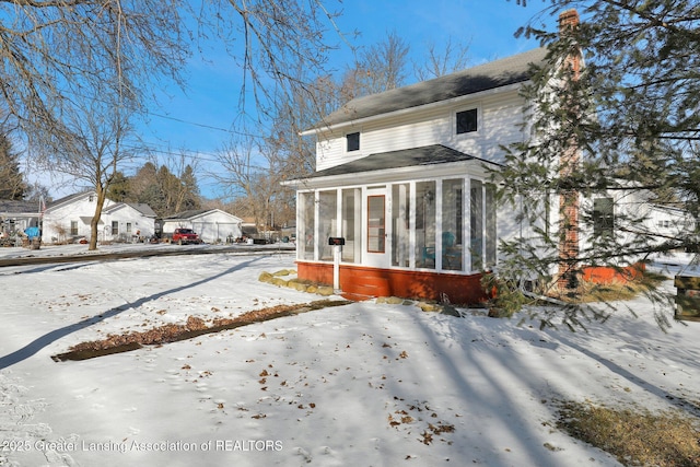 snow covered house with a sunroom