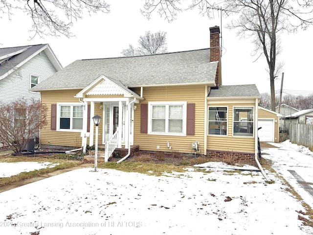 bungalow with a garage and an outbuilding