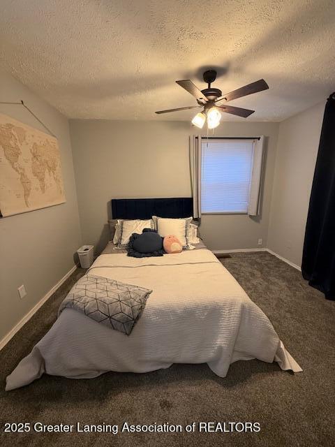 bedroom with ceiling fan, a textured ceiling, and dark carpet