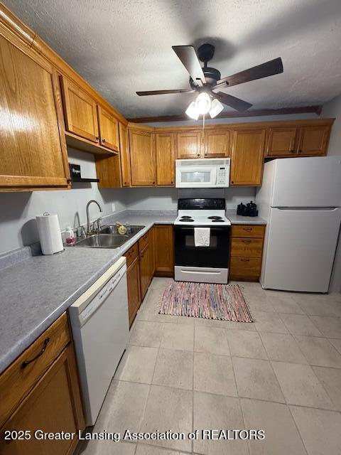 kitchen with sink, light tile patterned floors, white appliances, ceiling fan, and a textured ceiling