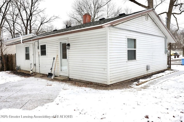 view of snow covered back of property