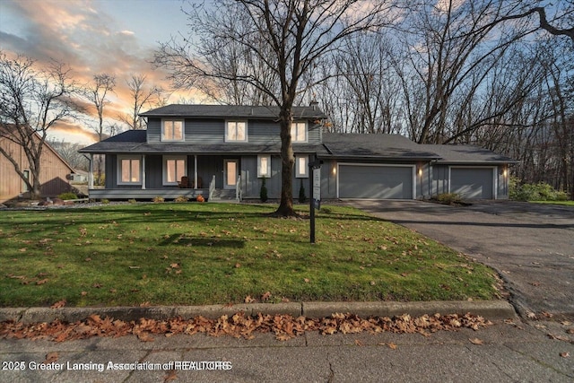 prairie-style home featuring a garage, a yard, and covered porch