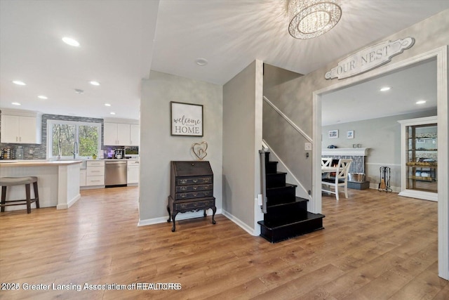 staircase with hardwood / wood-style flooring and sink