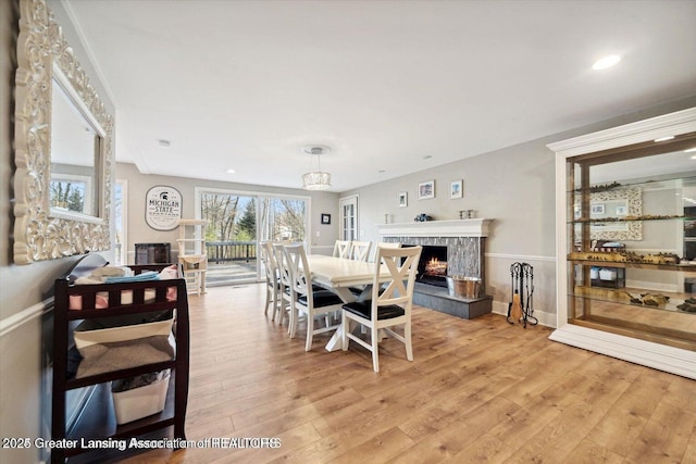 dining space with a tiled fireplace and hardwood / wood-style flooring