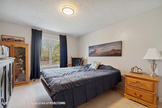 bedroom featuring light colored carpet and a textured ceiling