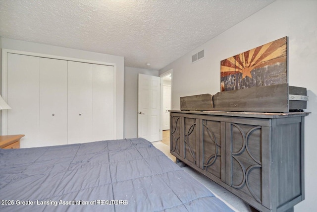 bedroom featuring a textured ceiling and a closet