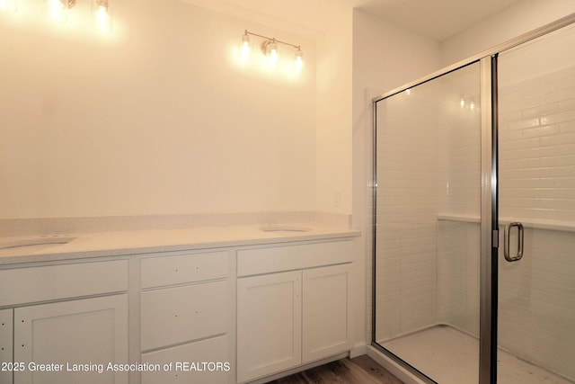 bathroom featuring an enclosed shower, sink, and hardwood / wood-style flooring