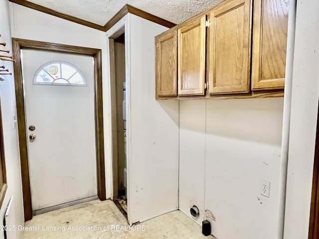 laundry room featuring cabinets and a textured ceiling