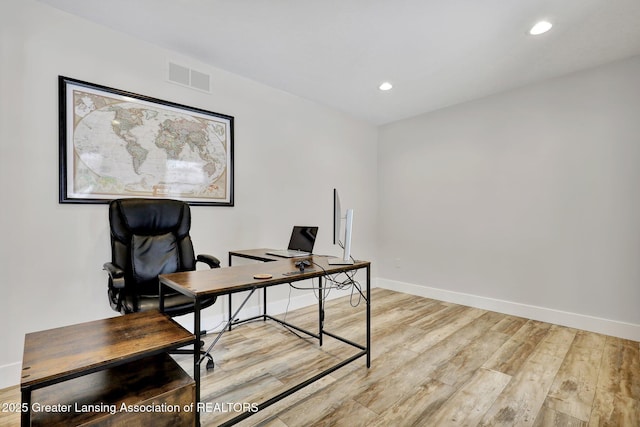 home office with light hardwood / wood-style floors