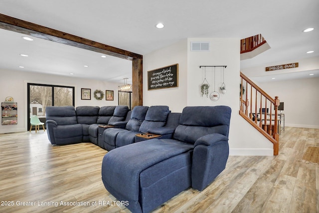 living room with beamed ceiling and light hardwood / wood-style flooring