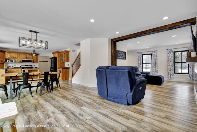 living room featuring beam ceiling and light wood-type flooring