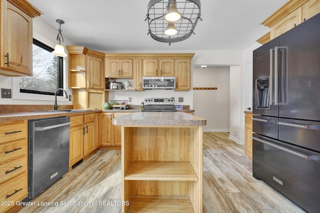 kitchen with sink, a center island, hanging light fixtures, light wood-type flooring, and stainless steel appliances