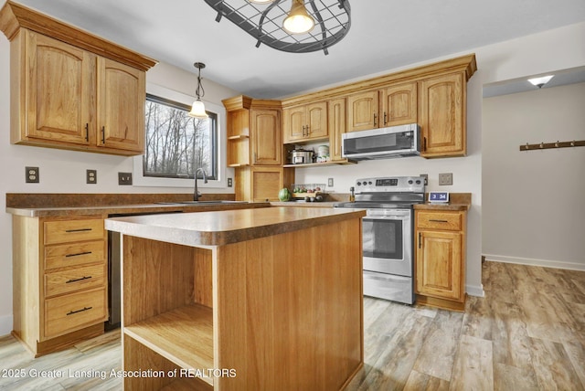 kitchen with stainless steel appliances, a kitchen island, hanging light fixtures, and light wood-type flooring