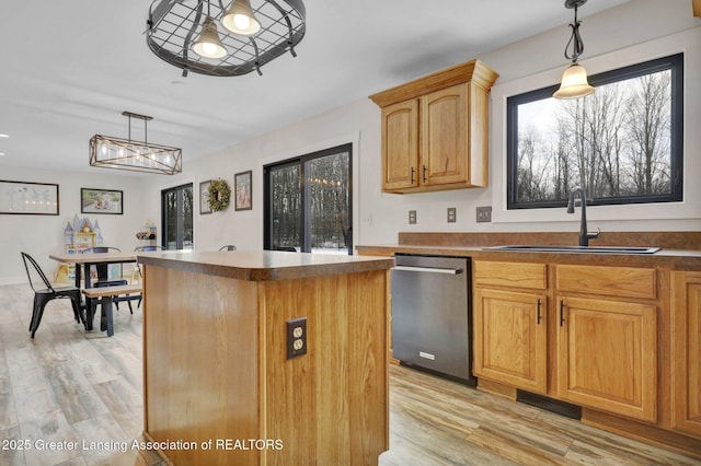 kitchen featuring a kitchen island, a wealth of natural light, decorative light fixtures, dishwasher, and sink