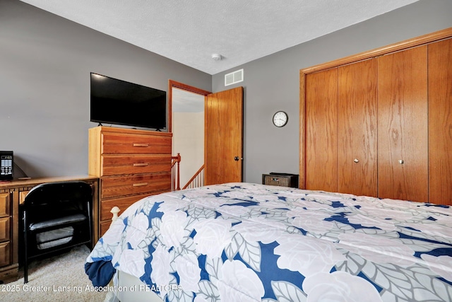 bedroom featuring light carpet, a closet, and a textured ceiling