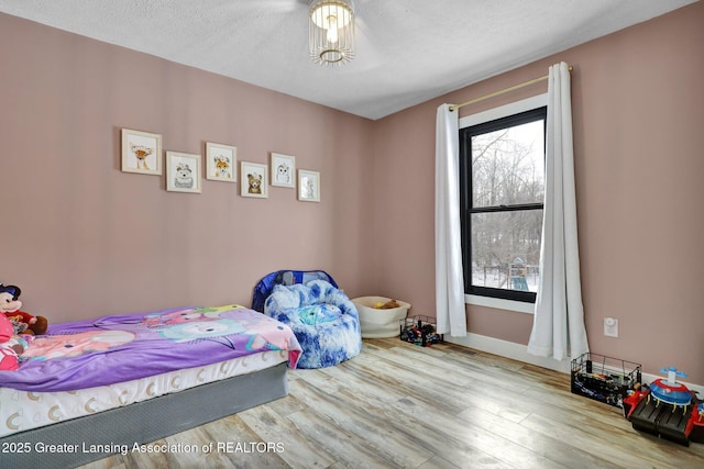 bedroom with a textured ceiling and light wood-type flooring