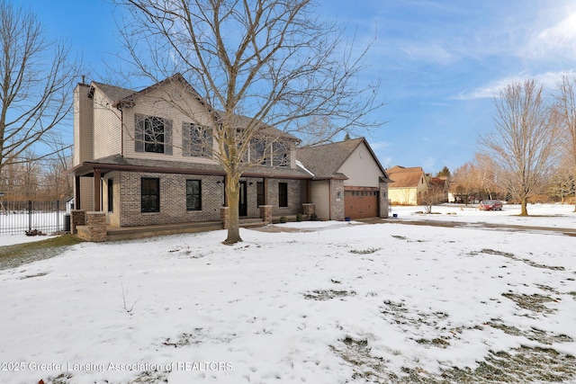 snow covered property with a garage