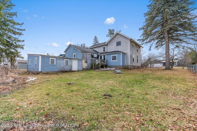 rear view of property with a yard and fence