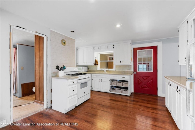 kitchen featuring white appliances, dark wood-style floors, light countertops, and a sink