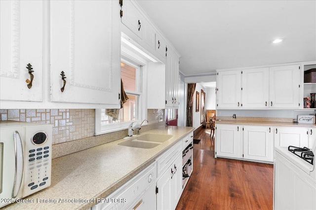 kitchen featuring open shelves, light countertops, dark wood-type flooring, white cabinets, and a sink