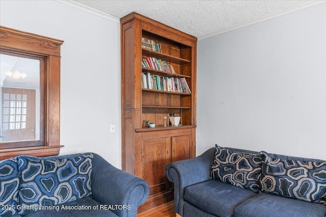 living room with a textured ceiling, ornamental molding, and built in features