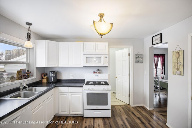 kitchen featuring pendant lighting, sink, white appliances, white cabinetry, and a wealth of natural light