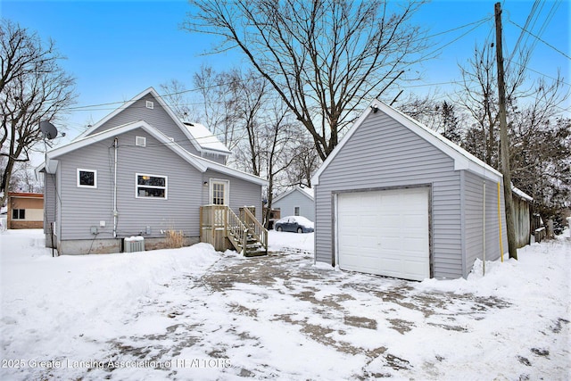 exterior space with central AC unit, a garage, and an outdoor structure