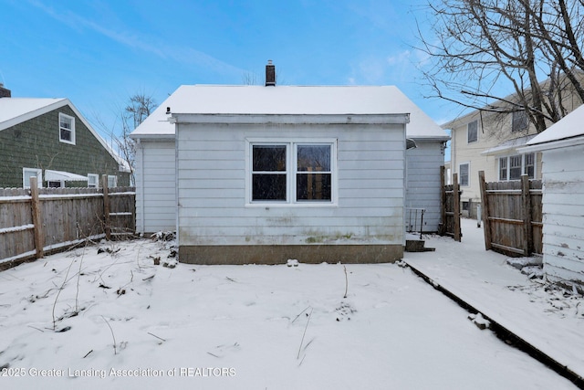 view of snow covered back of property
