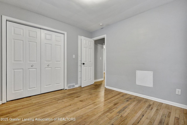 unfurnished bedroom featuring light hardwood / wood-style floors and a closet