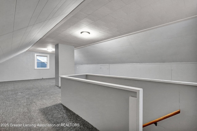 bonus room with lofted ceiling and carpet flooring