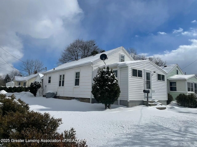 view of snow covered rear of property