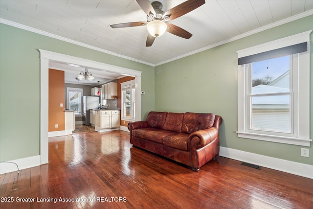 living room with crown molding, ceiling fan with notable chandelier, and hardwood / wood-style floors