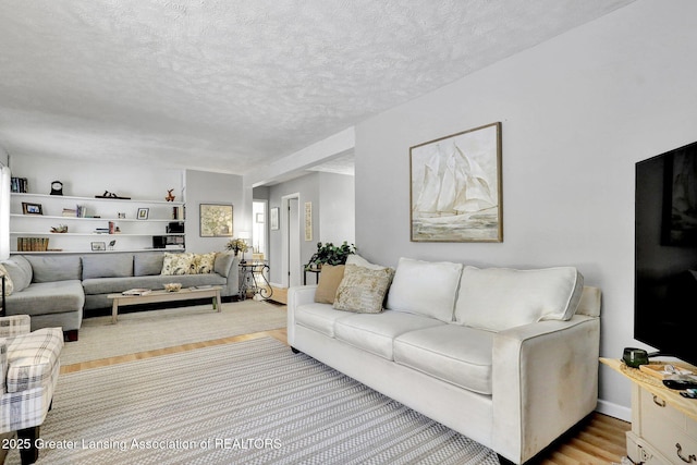 living room featuring a textured ceiling and light wood-type flooring