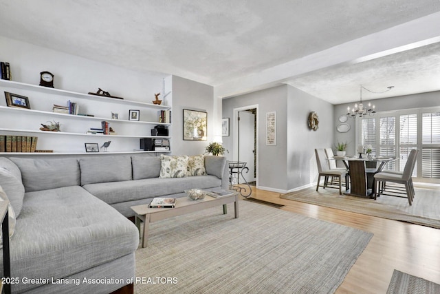 living room featuring a chandelier and light wood-type flooring