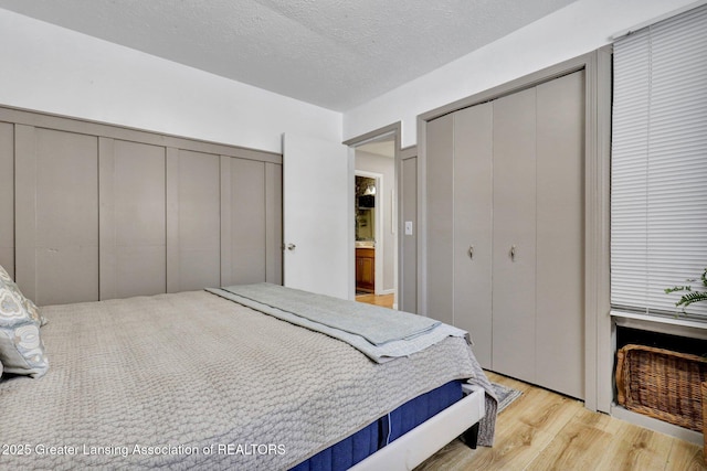 bedroom with a textured ceiling and light wood-type flooring