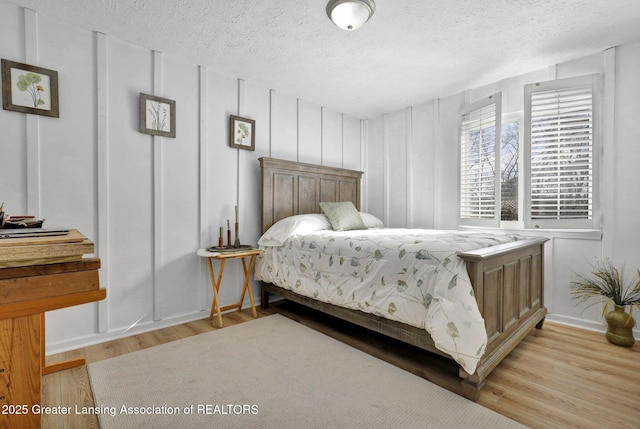 bedroom with a textured ceiling and light wood-type flooring