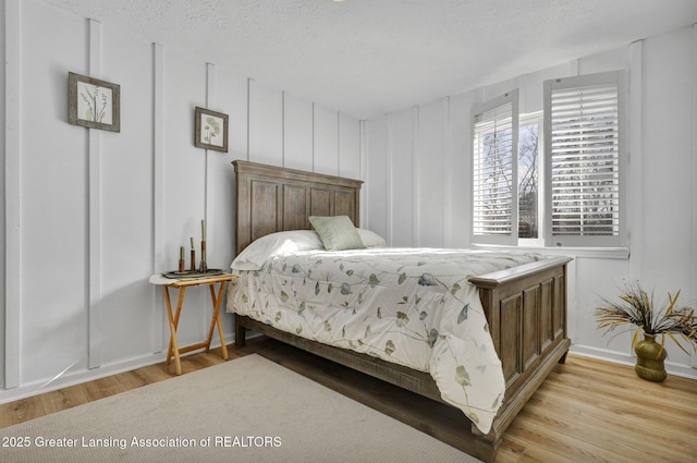 bedroom with light hardwood / wood-style flooring and a textured ceiling