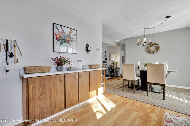 dining space featuring a notable chandelier and light wood-type flooring