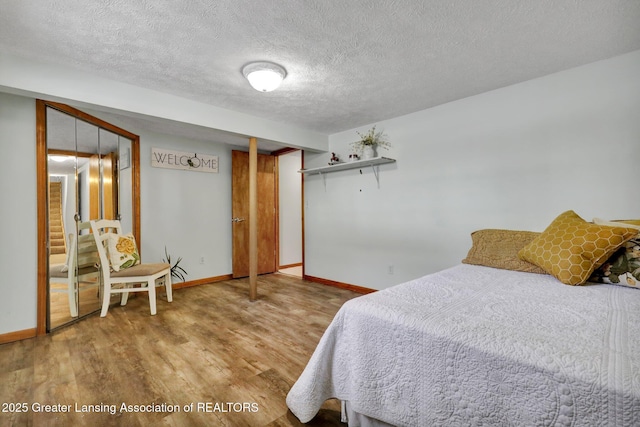 bedroom featuring a closet, hardwood / wood-style floors, and a textured ceiling