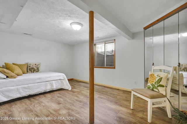 bedroom featuring hardwood / wood-style flooring, a closet, and a textured ceiling