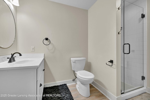 bathroom with vanity, hardwood / wood-style floors, an enclosed shower, and toilet