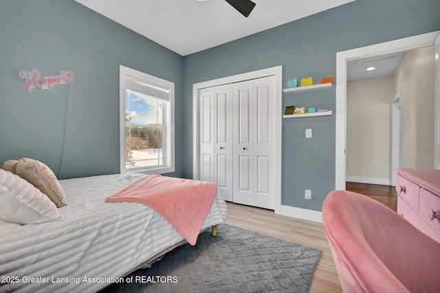 bedroom featuring wood-type flooring, ceiling fan, and a closet